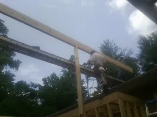Carpenter setting a ridge beam over a new addition frame — Ice Dam Removal by Roofing Brothers in New Canaan