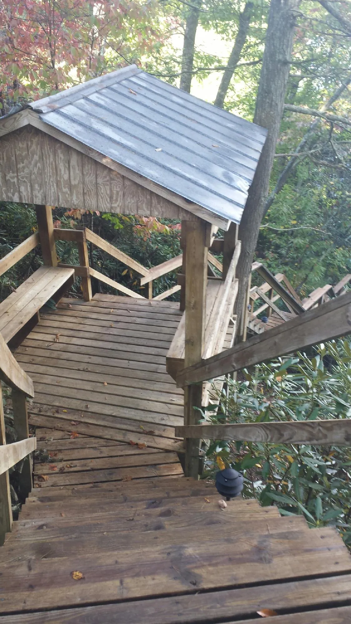 Metal roofed shelter over wooden steps on a wooded walkway — Skylight Repair & Installation work by our crew in New Canaan