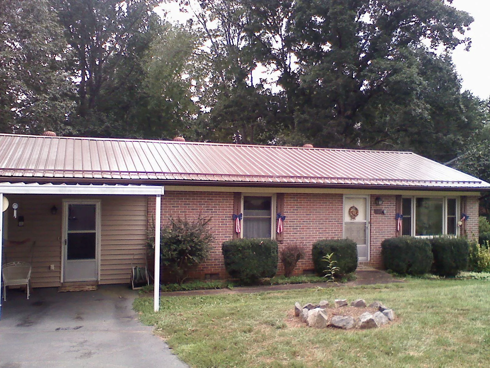 Bronze metal roof and carport on a brick ranch home — Roof Repair work by our crew in New Canaan